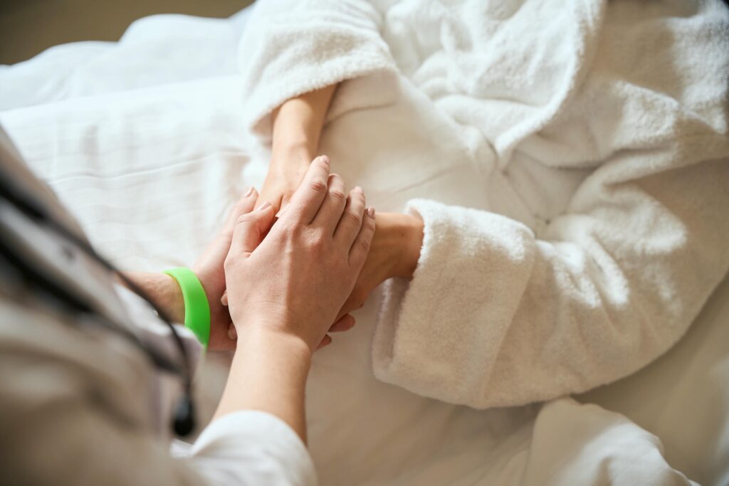 Hospice Nurse Holding a Patients Hand